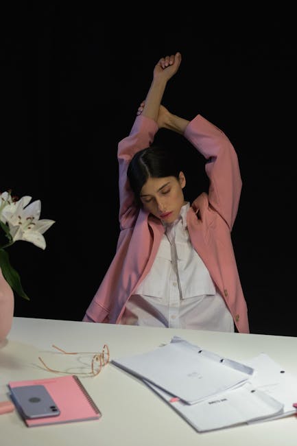Office worker gently stretching back at their workplace during a short break